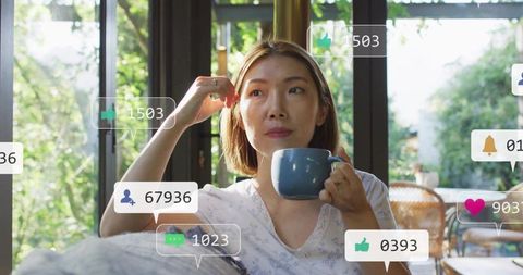 Chinese woman sipping from blue mug in bright living room with social media overlays