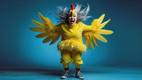 Woman enthusiastically posing in bright chicken costume in a crazy fun scene