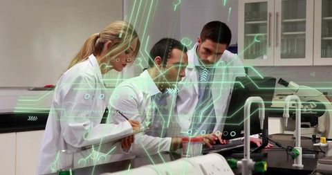 Collaborating scientists analyzing digital data on computer with futuristic overlay in laboratory