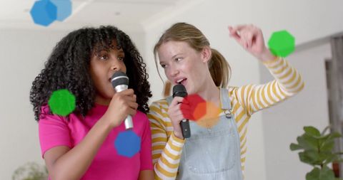Joyful teen girls singing karaoke at home with colorful lights
