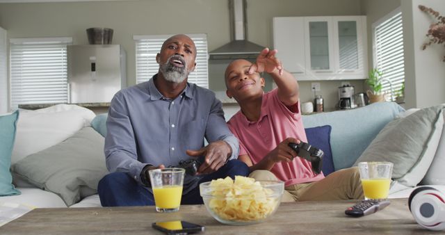 Father and Son Enjoying Video Game and Snacks Together at Home - Download Free Stock Images Pikwizard.com