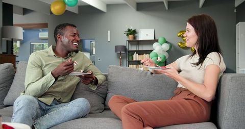 Happy Couple Enjoying Birthday Cake on Cozy Living Room Sofa