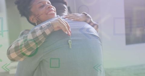A joyful couple embracing with keys to their new home