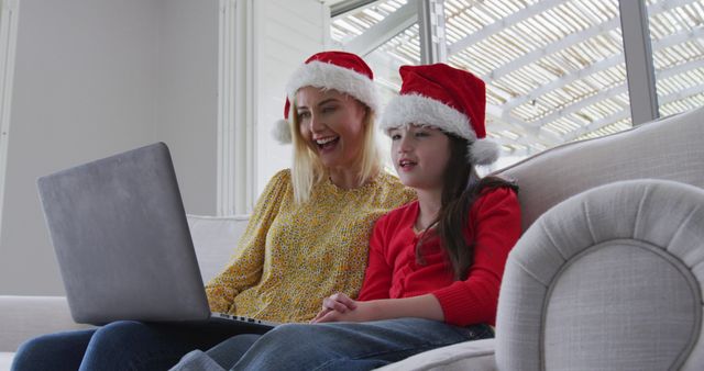Mother and daughter wearing Santa hats video chatting during Christmas - Download Free Stock Images Pikwizard.com