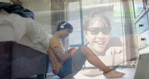 Young man sitting with headphones and basketball in double-exposure bedroom portrait