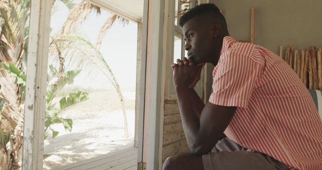 Pensive Man Sitting in Beachside Hut Contemplating Outdoors - Download Free Stock Images Pikwizard.com