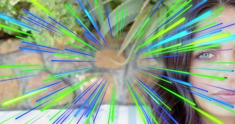 Gazing woman tilting face with blue-green radial light overlay near patio planter bench