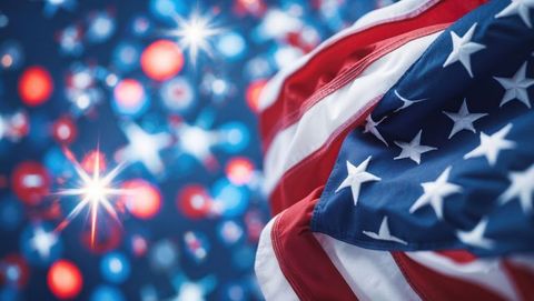 Flowing american flag with festive bokeh lights and star flares