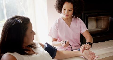 Nurse Monitoring Patient's Blood Pressure at Home