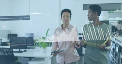 Businesswomen Analyzing Data in Modern Corporate Office