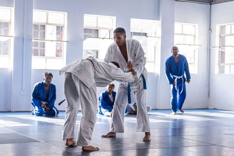 Martial Artists Practicing Grappling Techniques in Dojo