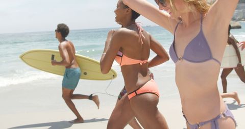 Friends Running on Sunny Beach with Surfboard