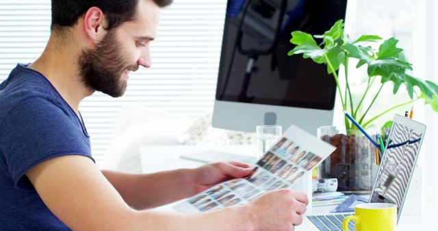 Designer Working at Desk with Printed Photos - Download Free Stock Images Pikwizard.com