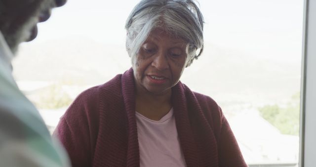 Senior Woman Conversing Near Window in Natural Light - Download Free Stock Images Pikwizard.com