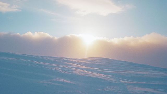 Sunrise Glow over Serene Snowy Tundra Landscape