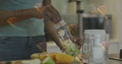 African American Woman Making Fresh Smoothie in Modern Kitchen