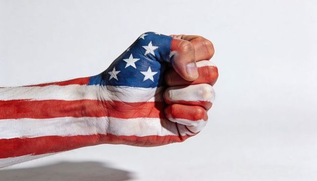 Clenching fist painted with american flag body paint conveying patriotic strength