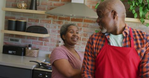Senior African American Couple Joyfully Cooking in Modern Kitchen
