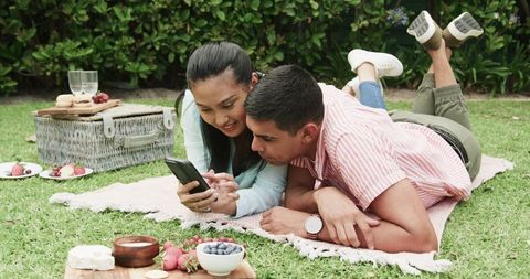 Young Couple Relaxing in Park During Romantic Picnic