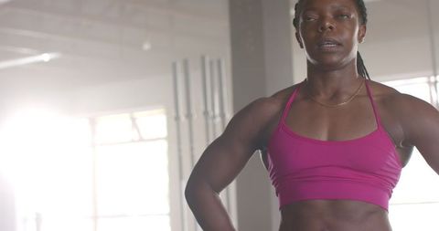 Confident Fit Woman Posing in Gym with Muscular Physique