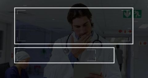 Doctor Holding Tablet in Hospital Corridor Illustrating Healthcare Professionalism