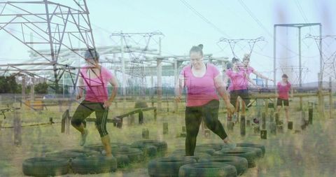 Women navigating tire course for outdoor fitness training