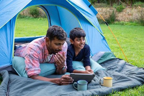 Father and Son Bonding with Tablet in Cozy Blue Tent on Lawn