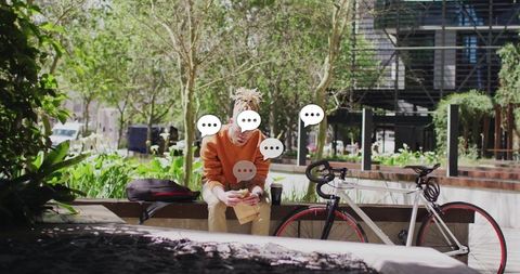 Man Relaxing Outdoors with Smartphone and Bicycle in Urban Plaza
