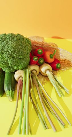 Colorful fresh vegetables display on yellow background
