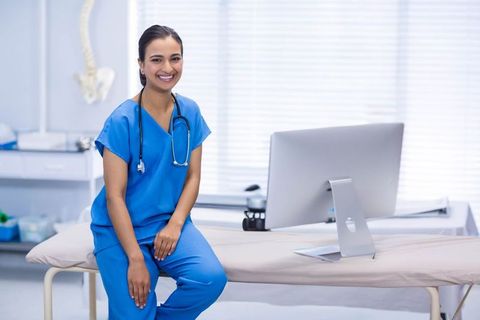 Medical Practitioner Sitting on Examination Table in Clinical Environment
