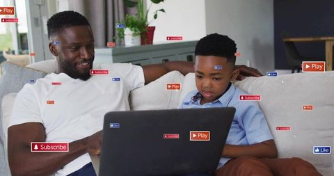 Father and Son Engaging in Digital Media Together at Home