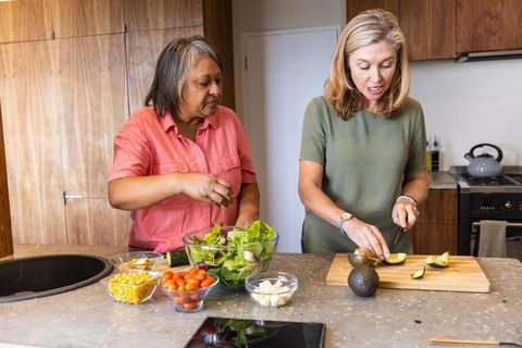 Two Senior Women Cooking Healthy Meal with Fresh Vegetables
