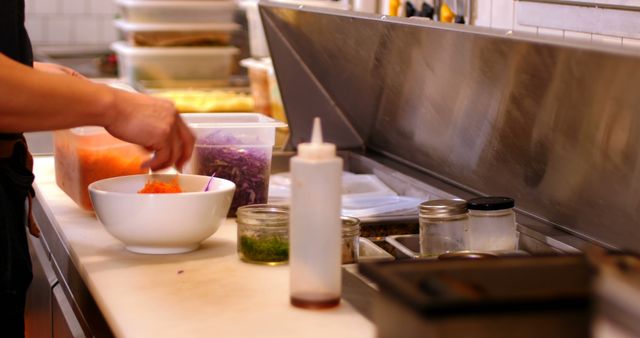 Chef preparing fresh ingredients in commercial kitchen, ideal for culinary blog posts, restaurant promotional materials, and cooking class advertisements. Highlights professional food preparation, conducive for promoting kitchen utensils and chef attire.