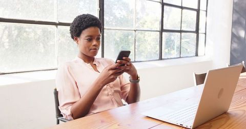 Businesswoman Staying Connected with Smartphone in Modern Office