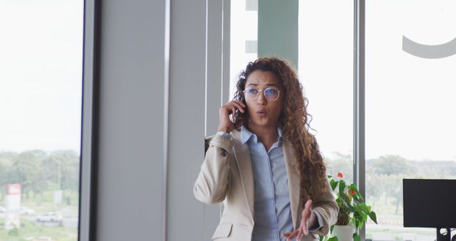 Businesswoman on Phone in Bright Modern Office Expressing Surprise - Download Free Stock Images Pikwizard.com