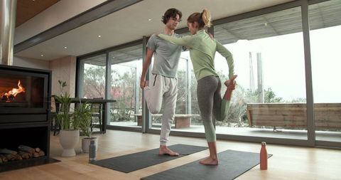 Two Women Practicing Yoga Stretch in Modern Living Room