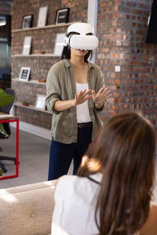 Diverse coworkers using vr headset in modern office lounge