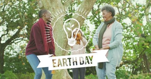 Multigenerational family celebrating Earth Day in park, child tossing autumn leaves