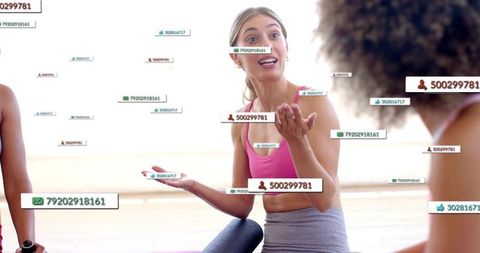 Leading instructor gesturing in sunlit yoga class with floating social tags and mats