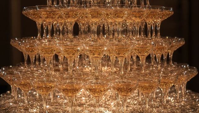 Golden Champagne Coupe Tower Glowing in Warm Light for Elegant Celebration