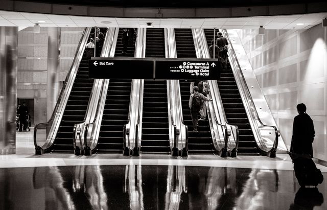 Travelers on Airport Escalator Following Wayfinding Signage - Download Free Stock Photos Pikwizard.com