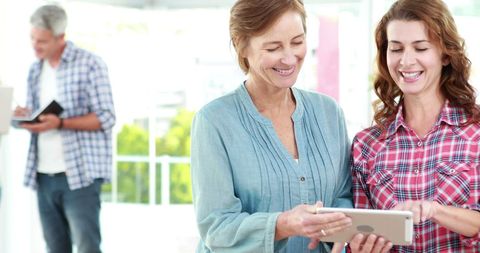 Two Women Collaborating on Tablet in Bright Modern Space - Download Free Stock Images Pikwizard.com