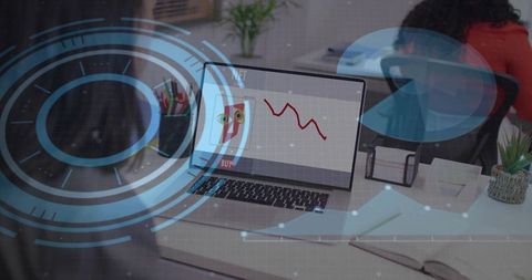 Displaying falling stock chart on laptop with augmented reality overlay in modern office