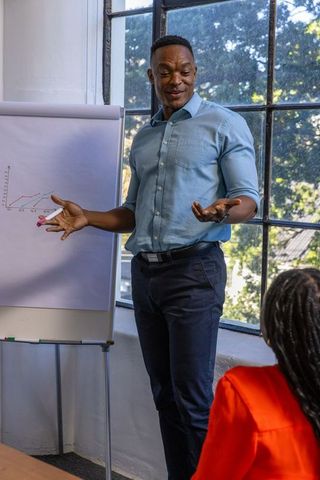 Businessman Presenting Line Graph in Office Meeting