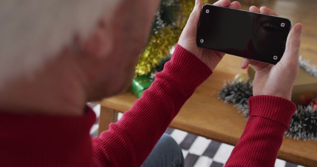 Man in Red Sweater Holding Smartphone During Holiday Season - Download Free Stock Images Pikwizard.com