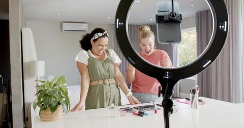 Young women creating online makeup content in modern studio setting