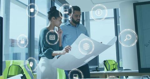 Colleagues Reviewing Blueprint with Digital Icons Representing Collaboration and Innovation