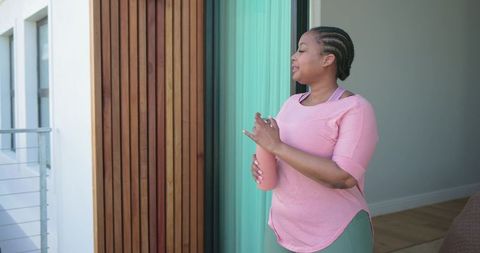 African american woman holding reusable water bottle in doorway for morning wellness