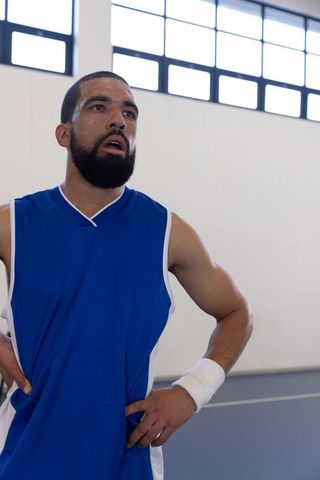 Determined Athlete Catching Breath Post-Training in Gym