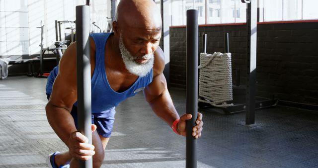 Senior man pushing weight sled in gym for strength training workout - Download Free Stock Images Pikwizard.com